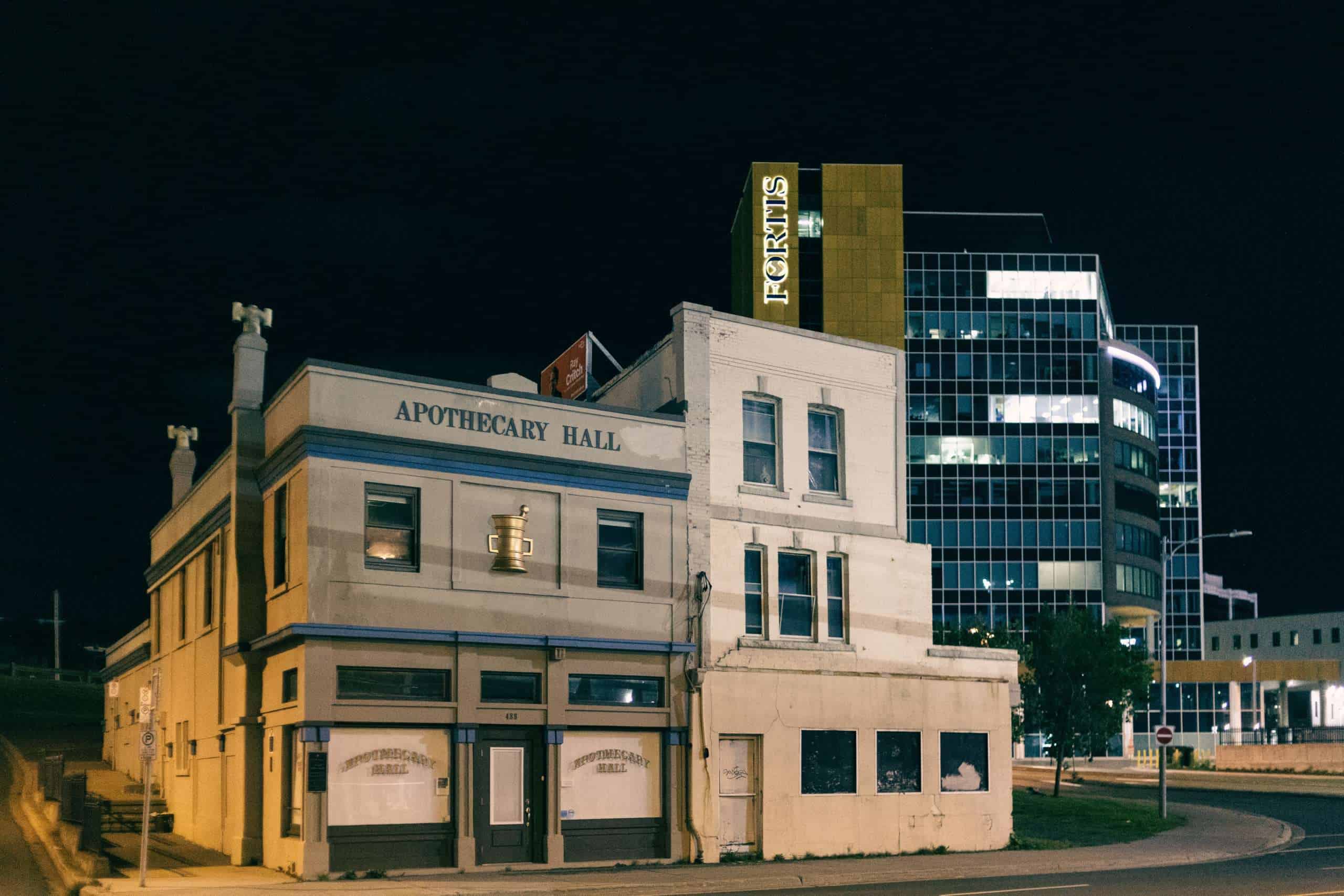 Apothecary Hall foregrounding the Fortis Building during nighttime in downtown St. John's
