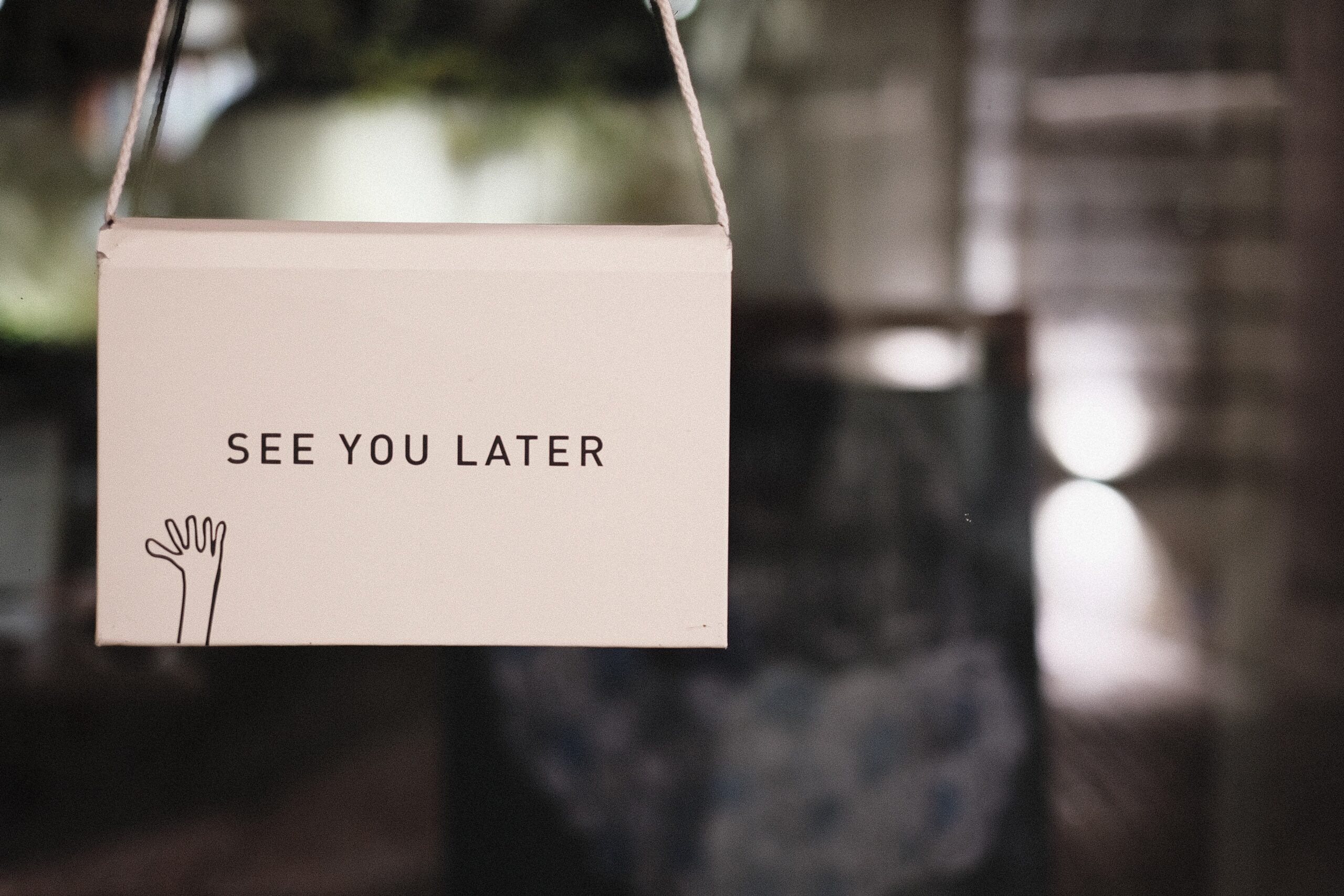 A sign reading "SEE YOU LATER" hangs in a window.